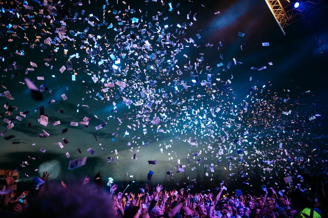 A crowd at a concert under falling confetti