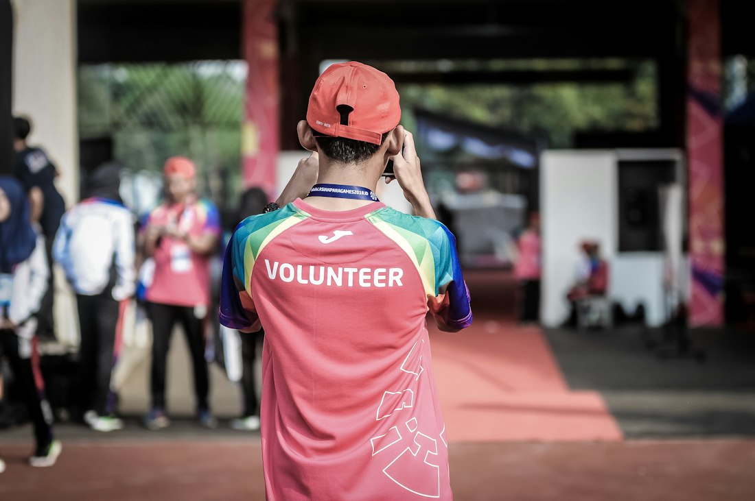 A volunteer in a pink shirt at a community event