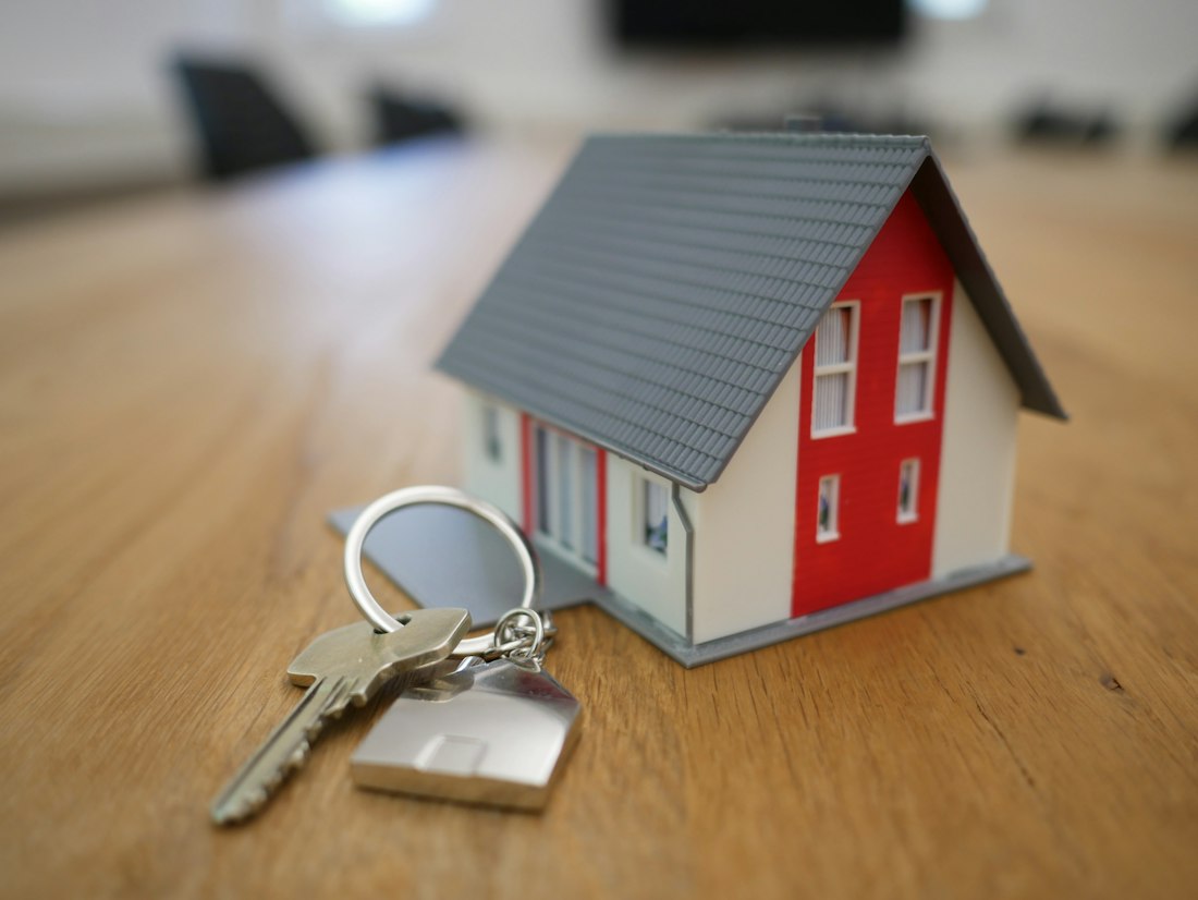 A model house and a set of keys on an agent's desk